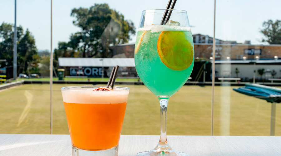 Two glasses of cocktail overlooking the bowling green at Engadine Bowlo